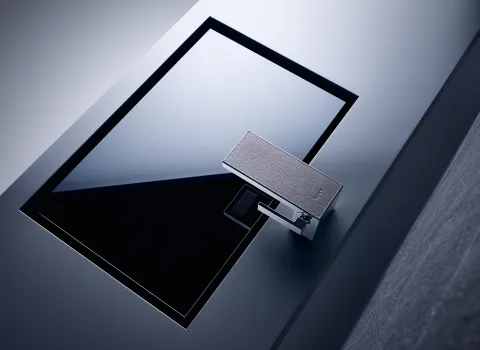Eine minimalistische, rechteckige Waschbecken-Armatur in modernem Design mit einer dunkel glänzenden Oberfläche.