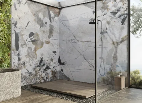 Ein luxuriöses Badezimmer mit einer offenen Dusche, deren Wände mit einem kunstvollen, marmorierten Muster in Grau-, Beige- und Schwarztönen gestaltet sind.