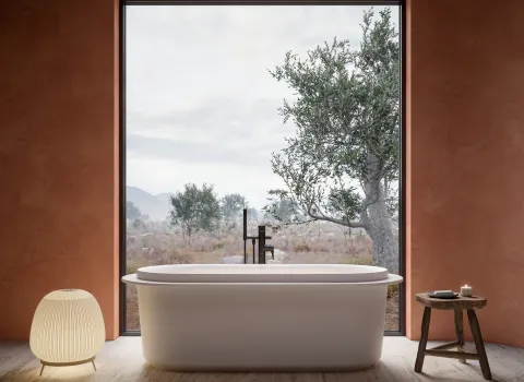 Freistehende Badewanne Vitrium der Marke Duravit vor Panoramafenster mit Blick in die Natur in ruhigem Badezimmerdesign.