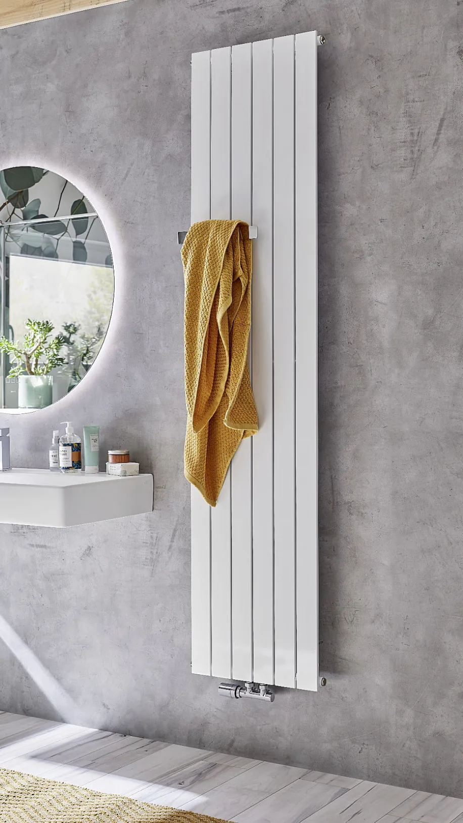 In einem stilvollen Badezimmer ist ein weißer HSK Alto Heizkörper an einer grauen Wand angebracht, mit einem gelben Handtuch, das locker darüber hängt.