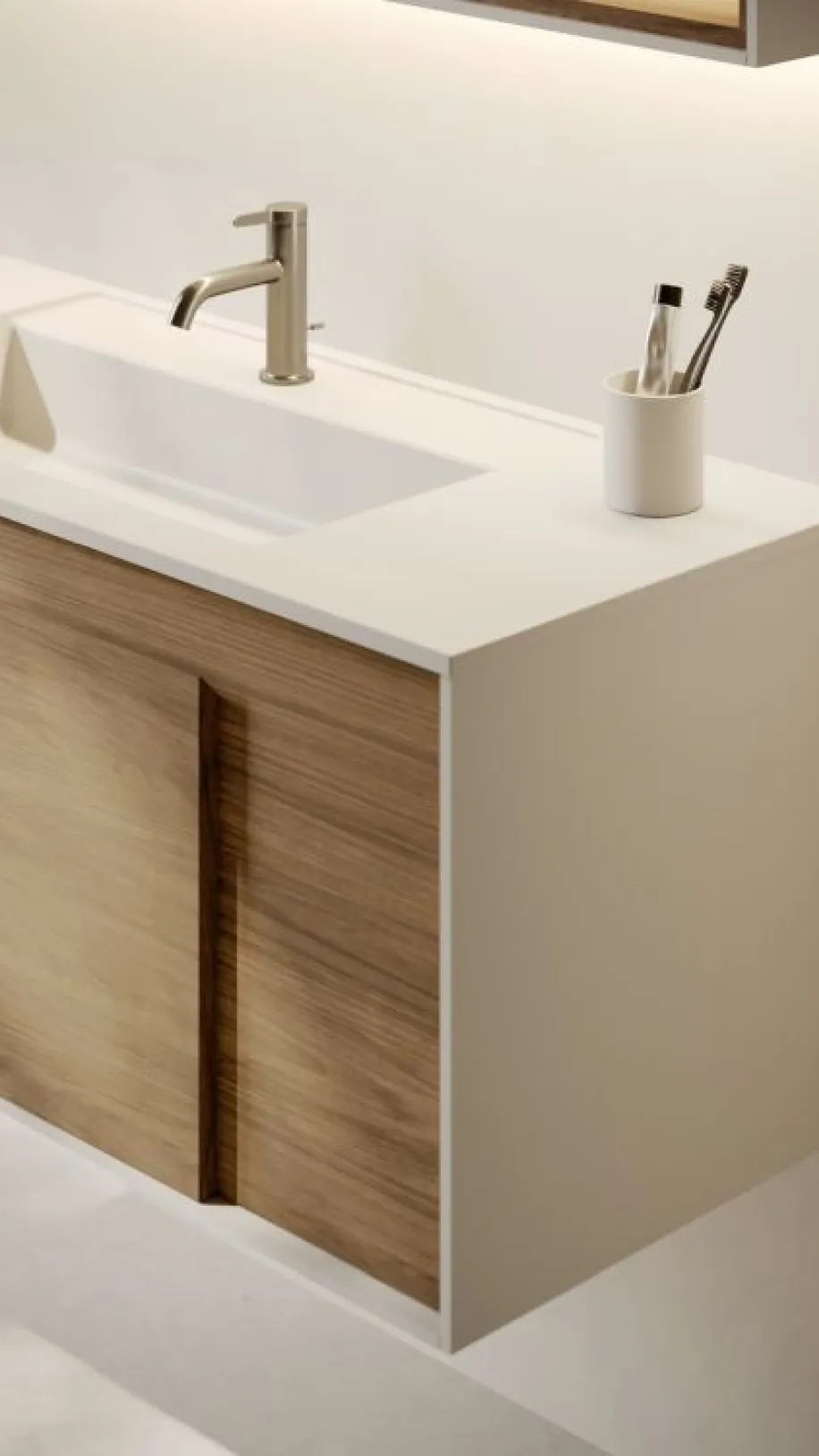 Das Bild zeigt einen Waschtisch mit weißer Oberfläche und klaren Kanten, kombiniert mit einer Front in realistischer Holzoptik.