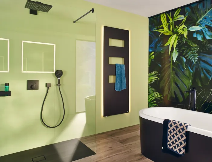 Ein modernes Badezimmer mit einer grün gestrichenen Wand und einer schwarzen Handbrause.