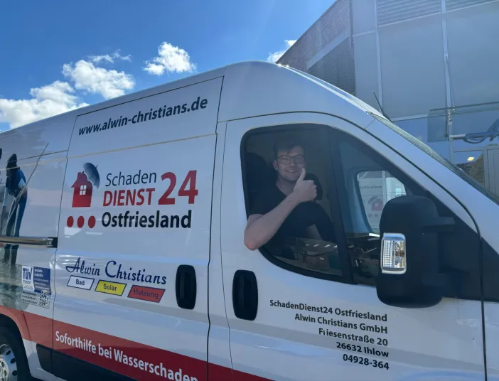 Ein Kundendienstmitarbeiter im Servicefahrzeug mit nach oben zeigenden Daumen.